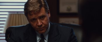 Movie still from “Broken City” (2013), directed by Allen Hughes – A person wearing a suit and tie; Close Up shot, Over the shoulder angle