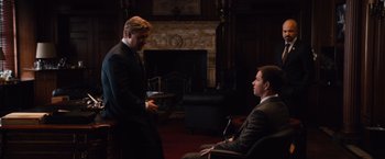 Movie still from “Broken City” (2013), directed by Allen Hughes – Two men in suits are talking in front of a fire place; Wide shot, Over the shoulder angle