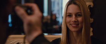 Movie still from “Broken City” (2013), directed by Allen Hughes – A woman smiles while taking a picture with her cell phone; Close Up shot, Over the shoulder angle