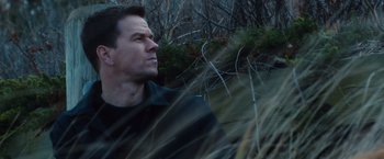 Movie still from “Broken City” (2013), directed by Allen Hughes – A person in a field near a bush; Close Up shot, Low angle
