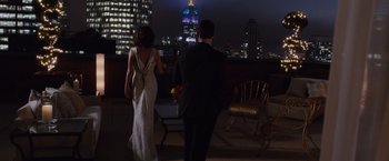 Movie still from “Broken City” (2013), directed by Allen Hughes – A man and a woman are standing on a balcony at night; Wide shot, Over the shoulder angle