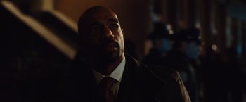 Movie still from “Broken City” (2013), directed by Allen Hughes – A person wearing a suit and tie; Close Up shot, Over the shoulder angle