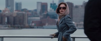 Movie still from “Broken City” (2013), directed by Allen Hughes – A woman in a gray coat and a scarf on a pier; Medium shot, Over the shoulder angle
