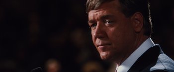 Movie still from “Broken City” (2013), directed by Allen Hughes – A person wearing a suit and tie; Close Up shot, Over the shoulder angle