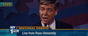 Movie still from “Broken City” (2013), directed by Allen Hughes – A man in a suit and tie on a tv screen; Close Up shot, High angle