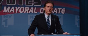 Movie still from “Broken City” (2013), directed by Allen Hughes – A man in a suit and tie at a podium; Close Up shot, Low angle