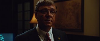 Movie still from “Broken City” (2013), directed by Allen Hughes – A person wearing a suit and tie; Close Up shot, Over the shoulder angle