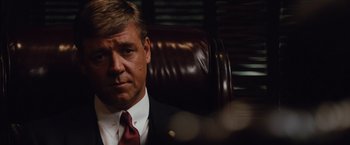 Movie still from “Broken City” (2013), directed by Allen Hughes – A person wearing a suit and tie; Close Up shot, Over the shoulder angle