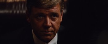 Movie still from “Broken City” (2013), directed by Allen Hughes – A person wearing a suit and tie; Close Up shot, Over the shoulder angle