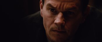 Movie still from “Broken City” (2013), directed by Allen Hughes – A man's face in a dark room; Close Up shot, Over the shoulder angle