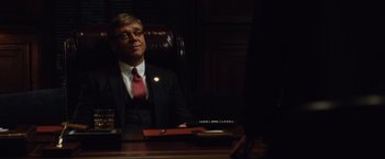 Movie still from “Broken City” (2013), directed by Allen Hughes – A man sitting at a desk in front of a computer; Medium shot, Over the shoulder angle