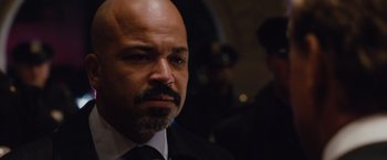 Movie still from “Broken City” (2013), directed by Allen Hughes – A man in a suit and tie looking at the camera; Close Up shot, Over the shoulder angle