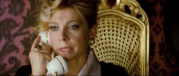 Movie still from “Broken Embraces” (2009), directed by Pedro Almodóvar – A woman sitting in a chair talking on a phone; Close Up shot, Low angle