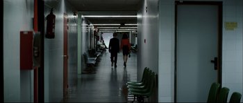 Movie still from “Broken Embraces” (2009), directed by Pedro Almodóvar – A man and a woman walking down a hall way; Wide shot, Over the shoulder angle