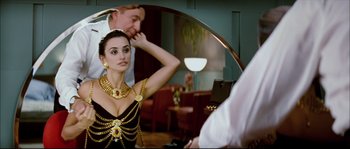Movie still from “Broken Embraces” (2009), directed by Pedro Almodóvar – A woman in a black and gold dress in front of a mirror; Medium shot, Over the shoulder angle