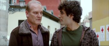 Movie still from “Broken Embraces” (2009), directed by Pedro Almodóvar – Two men standing next to each other on the street; Close Up shot, Over the shoulder angle