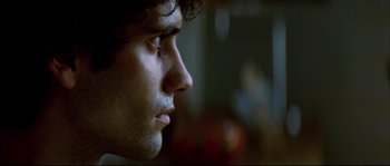 Movie still from “Broken Embraces” (2009), directed by Pedro Almodóvar – A man's face in a dark room; Close Up shot, Over the shoulder angle
