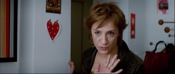 Movie still from “Broken Embraces” (2009), directed by Pedro Almodóvar – A woman in a leather jacket is looking at the camera; Close Up shot, Over the shoulder angle