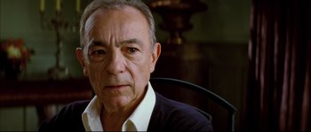 Movie still from “Broken Embraces” (2009), directed by Pedro Almodóvar – An older man sitting in front of a mirror in a room; Close Up shot, High angle