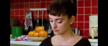 Movie still from “Broken Embraces” (2009), directed by Pedro Almodóvar – A person in a kitchen with oranges in the background; Close Up shot, Over the shoulder angle