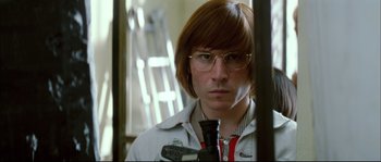 Movie still from “Broken Embraces” (2009), directed by Pedro Almodóvar – A man with glasses is looking into a mirror; Close Up shot, Low angle