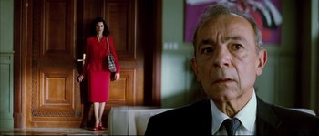 Movie still from “Broken Embraces” (2009), directed by Pedro Almodóvar – A woman in a red dress and a man in a black suit; Medium shot, Low angle