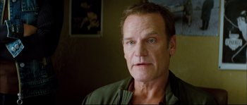 Movie still from “Broken Embraces” (2009), directed by Pedro Almodóvar – A person wearing a green jacket; Close Up shot, Low angle