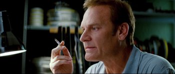 Movie still from “Broken Embraces” (2009), directed by Pedro Almodóvar – A person holding a cigarette; Close Up shot, Low angle