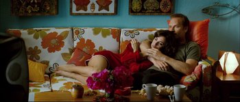 Movie still from “Broken Embraces” (2009), directed by Pedro Almodóvar – A woman laying on a couch in a living room; Medium shot, Overhead angle