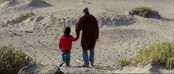 Movie still from “Broken Embraces” (2009), directed by Pedro Almodóvar – A man and a child walking on the beach; Wide shot, High angle