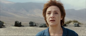 Movie still from “Broken Embraces” (2009), directed by Pedro Almodóvar – A person in a field with rocks in the background; Close Up shot, High angle