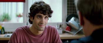 Movie still from “Broken Embraces” (2009), directed by Pedro Almodóvar – A person sitting in front of a window; Close Up shot, Over the shoulder angle