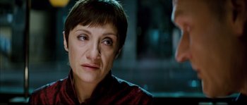 Movie still from “Broken Embraces” (2009), directed by Pedro Almodóvar – A person with short brown hair; Close Up shot, Over the shoulder angle