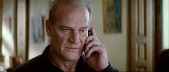 Movie still from “Broken Embraces” (2009), directed by Pedro Almodóvar – An older man talking on a cell phone; Close Up shot, Low angle