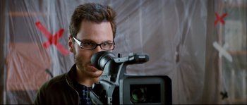 Movie still from “Broken Embraces” (2009), directed by Pedro Almodóvar – A person holding a video camera; Close Up shot, Over the shoulder angle
