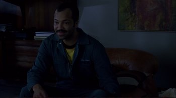 Movie still from “Broken Flowers” (2005), directed by Jim Jarmusch – A man sitting on top of a brown leather couch; Medium shot, High angle