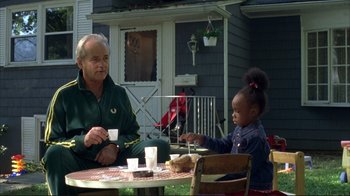 Movie still from “Broken Flowers” (2005), directed by Jim Jarmusch – An older man and a young girl sitting at an outside table; Medium shot, High angle