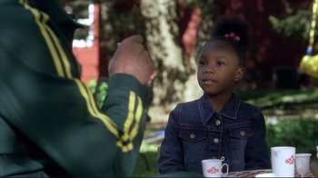 A little girl sitting at a table with a man
