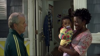 Movie still from “Broken Flowers” (2005), directed by Jim Jarmusch – An older man holding a baby in his arms and a woman holding a baby in her arms; Medium shot, Over the shoulder angle
