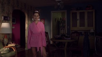 Movie still from “Broken Flowers” (2005), directed by Jim Jarmusch – A woman in a pink robe standing in a living room; Medium shot, Over the shoulder angle