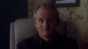 Movie still from “Broken Flowers” (2005), directed by Jim Jarmusch – A man sitting in a chair looking at the camera; Close Up shot, Over the shoulder angle