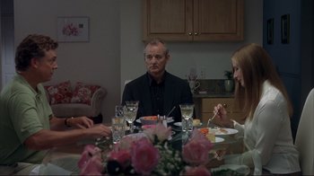 Movie still from “Broken Flowers” (2005), directed by Jim Jarmusch – A group of people sitting at a table with plates of food; Medium shot, Over the shoulder angle