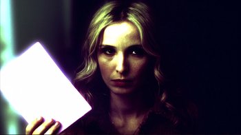 A woman holding a light in a dark room