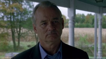 Movie still from “Broken Flowers” (2005), directed by Jim Jarmusch – A man in a suit and tie looking at the camera; Close Up shot, Over the shoulder angle