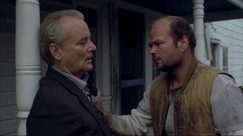 Movie still from “Broken Flowers” (2005), directed by Jim Jarmusch – Two men standing next to each other in front of a building; Close Up shot, Over the shoulder angle