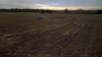 Movie still from “Broken Flowers” (2005), directed by Jim Jarmusch – A car is parked in the middle of an empty field; Extreme Wide shot, High angle