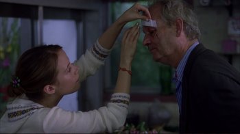 Movie still from “Broken Flowers” (2005), directed by Jim Jarmusch – An older man and a younger woman putting tape on their faces; Close Up shot, Over the shoulder angle