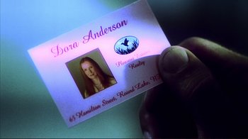 Movie still from “Broken Flowers” (2005), directed by Jim Jarmusch – A person holding a business card; Extreme Close Up shot, High angle