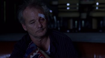 Movie still from “Broken Flowers” (2005), directed by Jim Jarmusch – A person with a bandage on his head; Close Up shot, Over the shoulder angle