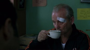 Movie still from “Broken Flowers” (2005), directed by Jim Jarmusch – An older man drinking a cup of coffee with bandages on his head; Medium shot, Low angle